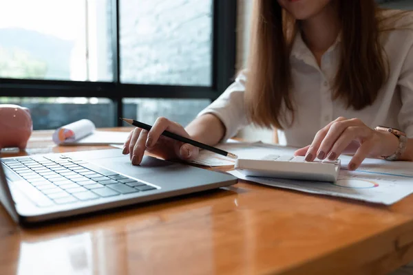 Concept de comptabilité d'entreprise, Business wpman utilisant la calculatrice et ordinateur portable, le budget et le papier de prêt au bureau — Photo