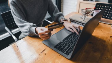 Kredi kartı tutan ve tablet bilgisayar kullanan Asyalı genç kadını kapatın. Evde çalışan bir iş kadını. Çevrimiçi alışveriş, e-ticaret, internet bankacılığı, harcama, ev konseptinden çalışma
