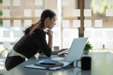 Modern ofiste dijital tablet kullanan mutlu Asyalı iş kadını. Pazarlama planı için mobil cihazlarda çalışan gençlerin kavramı.