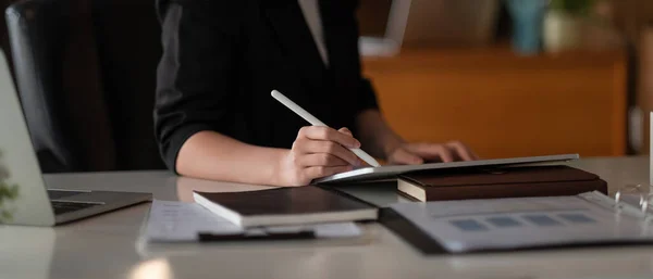 De cerca la mano de la mujer con lápiz lápiz óptico escribiendo en la tableta digital, tocando la pantalla de la tableta digital trabajando en el ordenador portátil en la oficina — Foto de Stock