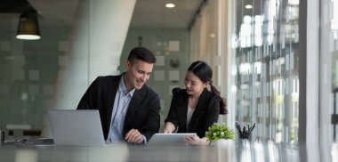 Çalışma odasında dizüstü bilgisayar ve dijital tabletle birlikte çalışan çeşitli iş adamları, iş planlama konsepti