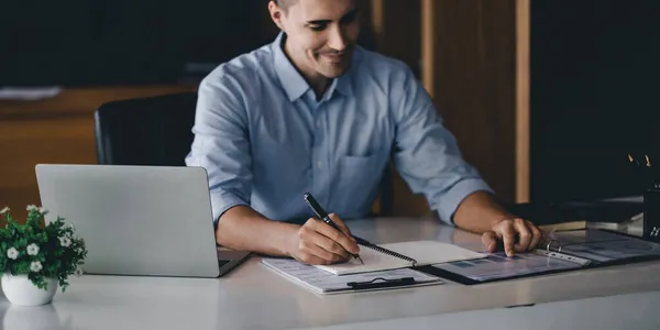 Primo piano mano di uomo d'affari con penna scrittura su taccuino. maschio che lavora per l'analisi finanziaria aziendale — Foto Stock