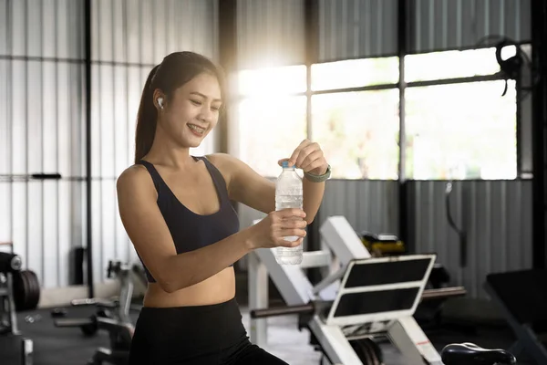 Asiática joven bebiendo agua después del entrenamiento en el gimnasio, saludable y el concepto de deporte. — Foto de Stock