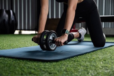 Asyalı sporcu kadının eli spor salonunda spor yaparken karın kasları egzersizi yapıyor. Kadın sağlık hizmetleri kavramı.