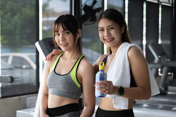 Retrato de dos spoty girl sonriendo fitness después de entrenar juntos en el gimnasio. — Foto de Stock