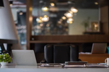 Bilgisayarlı, yeşil santralli ve modern ofis içi evraklı çalışma masası.