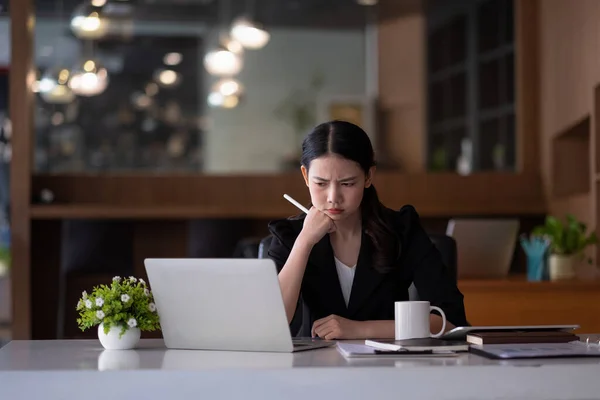 Asiatische Geschäftsfrau denken Problemlösung bei der Arbeit, besorgt ernsthafte junge asiatische Frau betroffen machen schwierige Entscheidung verloren in Gedanken reflektieren sitzen mit Laptop. — Stockfoto