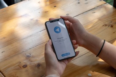 CHIANG MAI, THAILAND, JUL 27, 2021: Ekranda sosyal ağ hizmetleri telgrafıyla iPhone X 'i tutan kadın. iPhone 10 Apple Inc. tarafından oluşturuldu ve geliştirildi