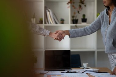 Yeni meslektaşlarımızı selamlıyoruz, iş adamları anlaşma imzalamak ve iş ortağı olmak için toplantı sırasında el sıkışıyor. İş ahlakı, tebrik, birleşme ve satın alma kavramı