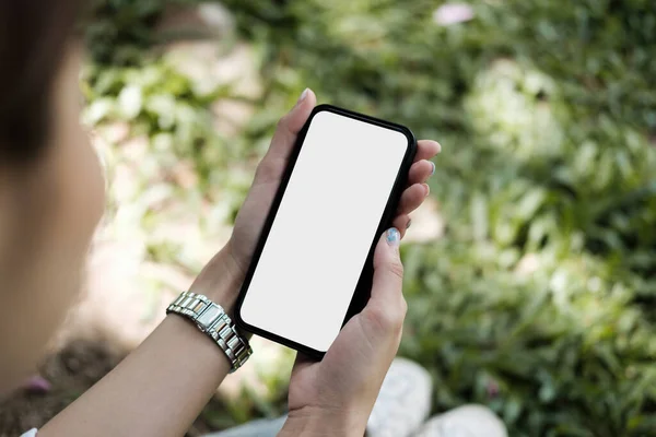 Imagen de maqueta de vista superior de una mujer sosteniendo un jardín al aire libre de teléfono móvil negro — Foto de Stock