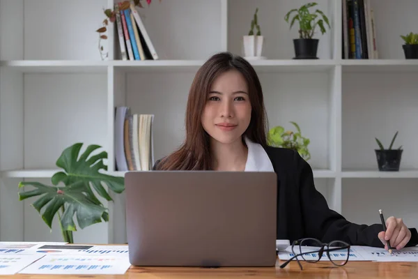 Profesyonel Asyalı kadın iş başında. Finansal danışman bir iş kadınını dizüstü bilgisayarla çalışırken ve ofiste evrak işleriyle uğraşırken çektim. — Stok fotoğraf