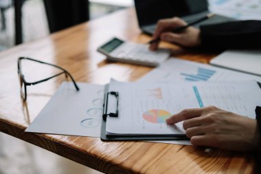 Bütçe ve kredi kağıtlarını hesaplamak için hesap makinesi kullanan muhasebeci