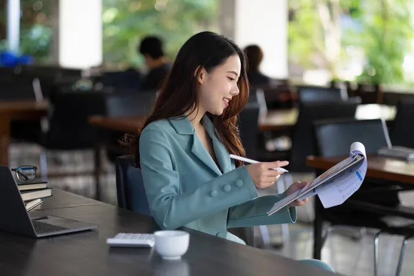 Negócios mulher asiática usando smartphone para fazer matemática finanças em mesa de madeira no escritório, imposto, contabilidade, conceito financeiro. — Fotografia de Stock