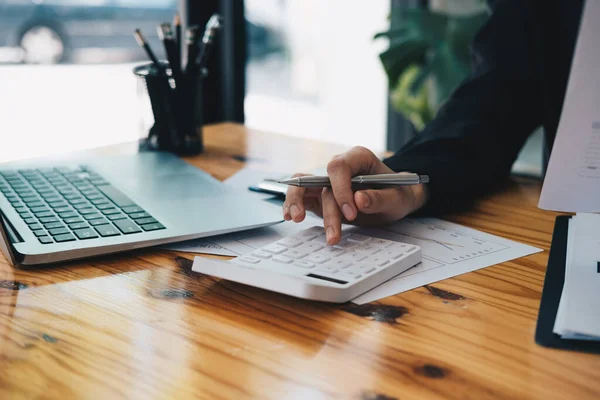 Närbild en revisor som arbetar med ekonomi med miniräknare på sitt kontor för att beräkna kostnader, Accountigng koncept — Stockfoto