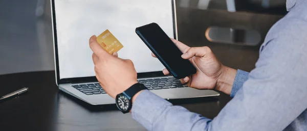 Pago en línea, Cierre las manos de los hombres sosteniendo el teléfono inteligente y utilizando la tarjeta de crédito para compras en línea — Foto de Stock