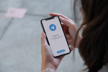 CHIANGMAI, THAILAND, 28 NOV 2021: Ekranda sosyal ağ hizmetleri telgrafı olan iPhone x 'lerle el ele tutuşan kadın
