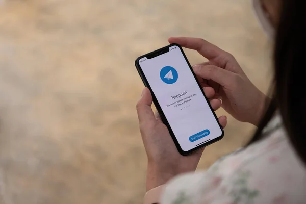 CHIANG MAI, THAILAND, NOV 14, 2021: Mão de mulher segurando iPhone X com serviço de rede social Telegrama na tela. iPhone 10 foi criado e desenvolvido pela Apple Inc — Fotografia de Stock