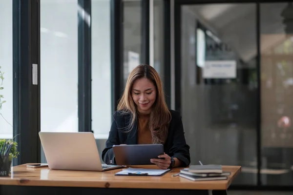 Dijital tablet ve dizüstü bilgisayarda çalışan Asyalı kadın. Gülümseyen kadın ofiste çalışmakla meşgul. — Stok fotoğraf