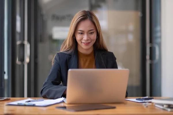 Χαμογελώντας όμορφη νεαρή Ασιάτισσα που εργάζεται σε φορητό υπολογιστή, επιχειρηματική οικονομική έννοια. — Φωτογραφία Αρχείου