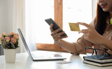 Happy woman using mobile app to online shopping and pay whit credit card at home