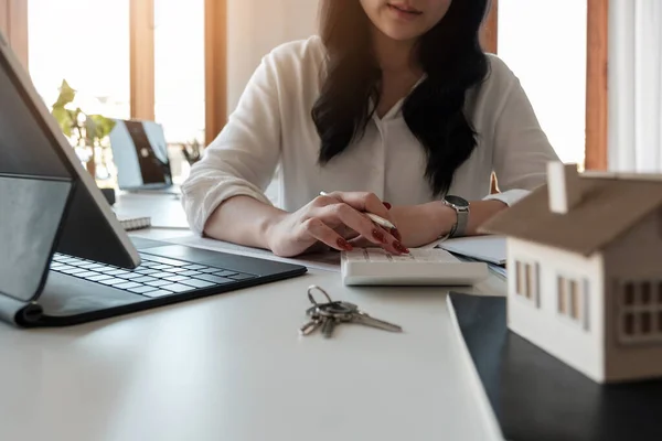 De cerca la mano de Negocios mujer asiática utilizando el cálculo de intereses, impuestos y beneficios para invertir en bienes raíces y la compra de una casa. — Foto de Stock