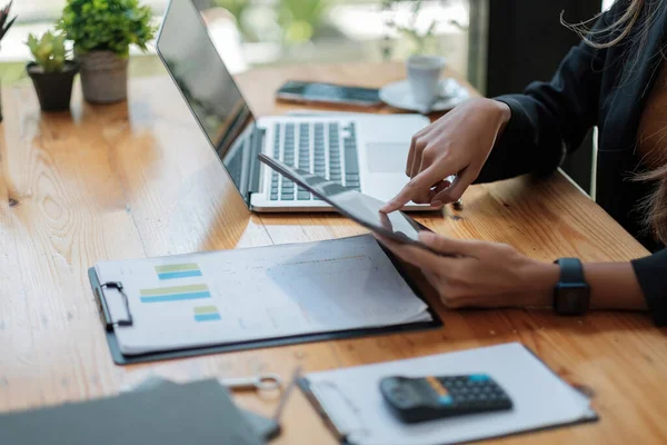 Close up business woman hands holds tablet pad while calculating charts profit and calculating financial report. business financial concept — Stockfoto