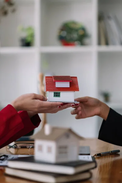 Real estate agent sales manager holding house model to customer after signing rental lease contract of sale purchase agreement, concerning mortgage loan offer for and house insurance — Stock Fotó