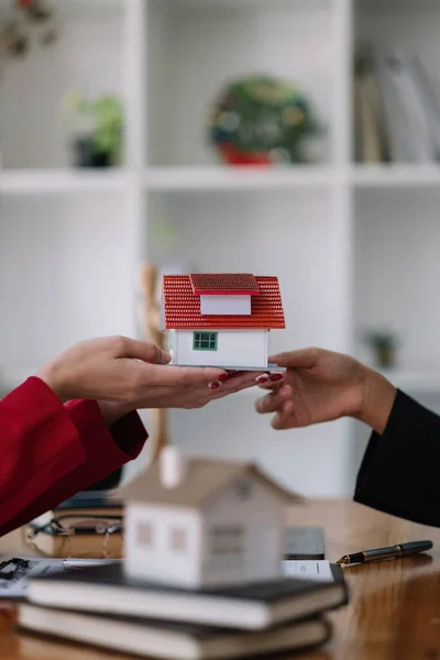 Real estate agent sales manager holding house model to customer after signing rental lease contract of sale purchase agreement, concerning mortgage loan offer for and house insurance — Stok fotoğraf