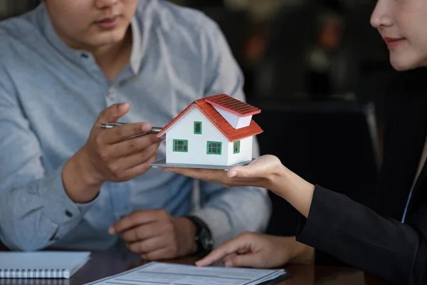 Real estate agent sales manager holding house model to customer after signing rental lease contract of sale purchase agreement, concerning mortgage loan offer for and house insurance — 图库照片