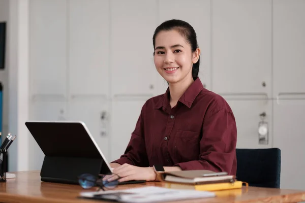 Портрет привлекательной предпринимательницы азиатки, деловой женщины, смотрящей в камеру во время работы в бухгалтерском учете с ноутбуком. — стоковое фото