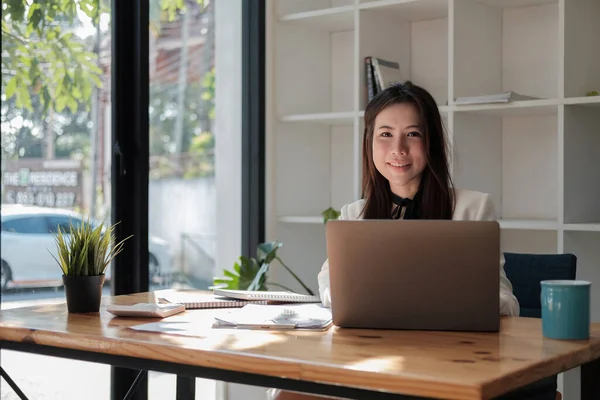 Mulher asiática encantadora com um sorriso trabalhando para o plano de marketing financeiro usando computador portátil — Fotografia de Stock