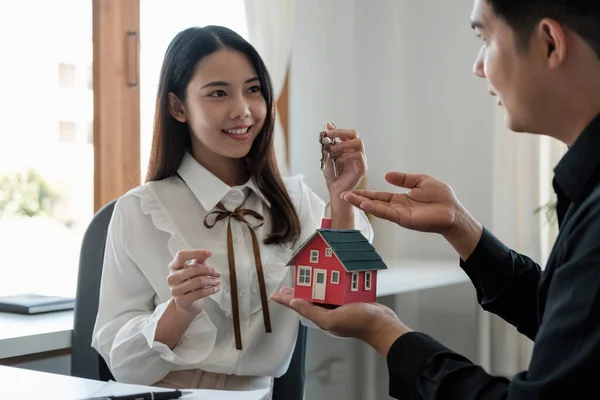 Realitní makléř vysvětluje styl domu klientům, kteří přicházejí do kontaktu se podívat na návrh domu a kupní smlouvu — Stock fotografie