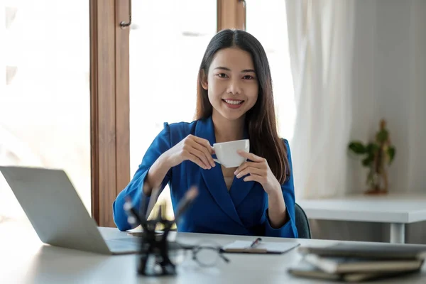 Πορτρέτο της χαμογελαστής ασιάτισσας επιχειρηματία που εργάζεται με φορητό υπολογιστή στο γραφείο της — Φωτογραφία Αρχείου