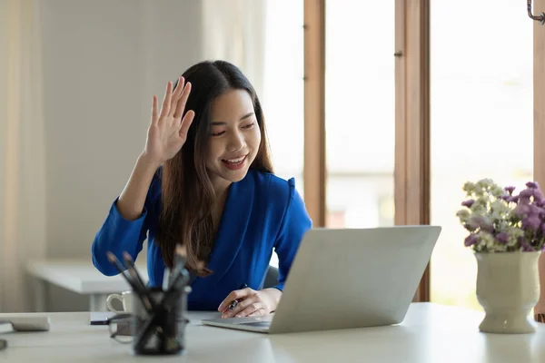 Asiens Geschäftsfrau spricht per Laptop mit Kollegen in Videotelefonaten über ihre Pläne, während sie von zu Hause aus im Wohnzimmer intelligent arbeitet. Selbstisolierung, soziale Distanzierung, Quarantäne zur Coronavirus-Prävention — Stockfoto