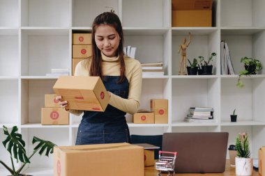 Genç Asyalı kadın eve nakliye siparişini kontrol ediyor, iş sahibi kadın internet üzerinden iş kuruyor, KOBİ, Teslimat projesi, Çevrimiçi iş veya KOBİ konsepti olan kadın.
