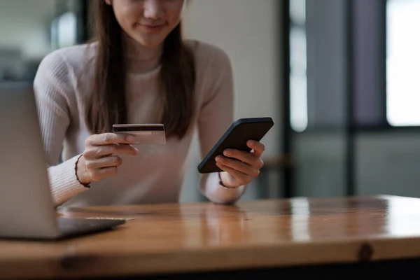 Jovem segurando cartão de crédito e usando telefone inteligente para compras online. Conceito de compras de pagamento online. — Fotografia de Stock