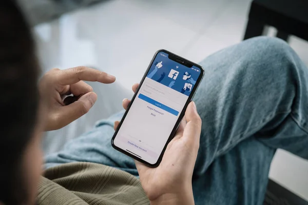 CHIANG MAI, TAILANDIA - 12 DE FEB DE 2022: Facebook social media app logo on log-in, sign-up registration page on mobile app screen on iPhone X in persons hand working on e commerce shopping business. — Foto de Stock
