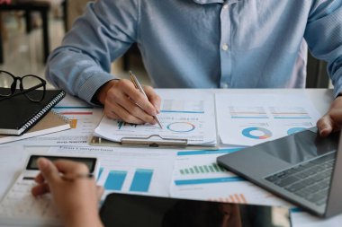 Finans, vergi, muhasebe, istatistik ve analitik araştırma konseptini hesaplamak için hesap makinesi ve dizüstü bilgisayar kullanarak iş adamı ve ortağını kapat