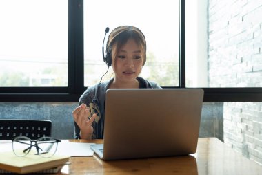 Kafe kafeteryasında kız öğrenci çalışması. Üniversite sınavı için bilgisayarı kullanıyor ve internetten öğreniyor.