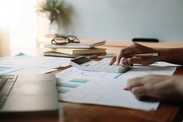 Närbild en man som arbetar med ekonomi med miniräknare på sitt kontor för att beräkna kostnader, Redovisning koncept — Stockfoto