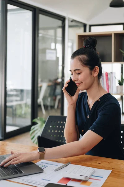 Retrato de mulher de negócios asiática fazendo telefonema enquanto trabalhava com computador portátil para contabilidade financeira. — Fotografia de Stock