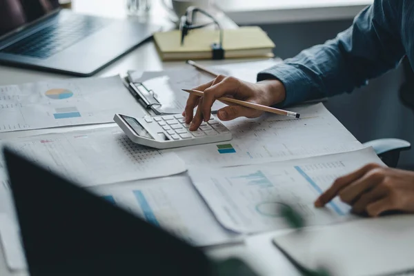 Крупним планом бізнесмен працює на столі за допомогою калькулятора аналізу фінансового обліку в офісі — стокове фото