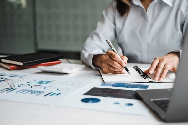 Close up mujer de negocios que trabaja con datos financieros mano utilizando la calculadora y la escritura tomar nota con calcular. Concepto financiero y contable empresarial — Foto de Stock