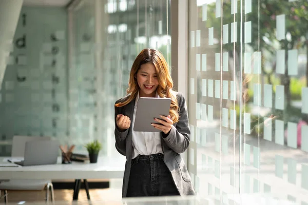 Porträt attraktive junge asiatische Geschäftsfrau mit digitalem Tablet feiern Erfolg oder glückliche Pose. — Stockfoto