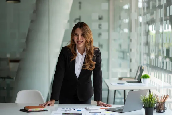 Portret van aantrekkelijke Aziatische zakenvrouw werken op laptop voor marketing plan met papierwerk — Stockfoto