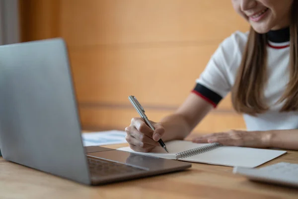 Joven mujer asiática escribiendo notas en cuaderno viendo webinar curso de vídeo, estudiante masculino negro serio mirando a la computadora portátil escuchar estudio conferencia en línea en e aprendizaje por ordenador — Foto de Stock