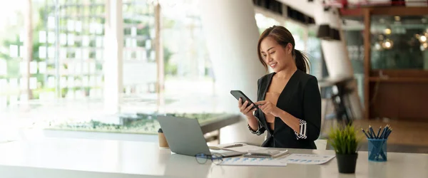 Mulher asiática de negócios usando telefone celular durante a verificação de um e-mail ou mídia social na internet. conceito financeiro contabilístico. — Fotografia de Stock