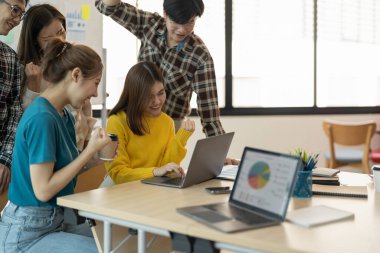 Genç iş adamlarından oluşan bir grup zaferi silahlarıyla kutluyor. Çeşitli iş adamları toplantı odasında mutlu bir başarı yakaladılar..