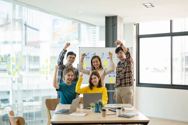 Ομάδα νέων επιχειρήσεων εκκίνησης ομάδα γιορτάζει έναν θρίαμβο με τα χέρια ψηλά, Διαφορετικοί επιχειρηματίες ευτυχισμένη επιτυχία στην αίθουσα συνεδριάσεων. — Φωτογραφία Αρχείου
