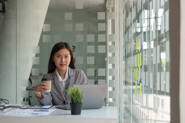 Charmosa mulher de negócios asiática sentada trabalhando no laptop no escritório. — Fotografia de Stock